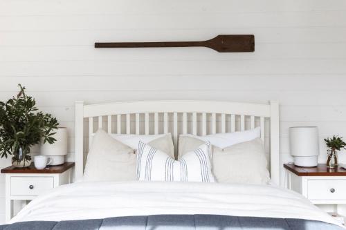 a bedroom with a white bed with white pillows at Historic 1850s Magnetic Cottage in Port Fairy