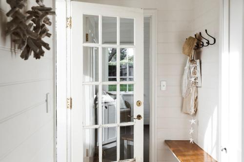 a door leading into a hallway with white walls at Historic 1850s Magnetic Cottage in Port Fairy