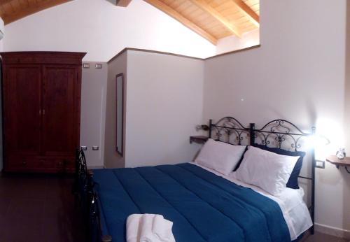 una camera con un letto e una coperta blu di Affittacamere Carpe Diem a Gonnosfanàdiga