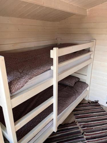 a bedroom with two bunk beds in a cabin at Suure-Kuuse kämpingud otse järve kaldal in Valma