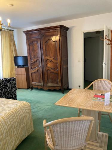a room with a large wooden cabinet and a table at Le Grand Paris in Digne-les-Bains
