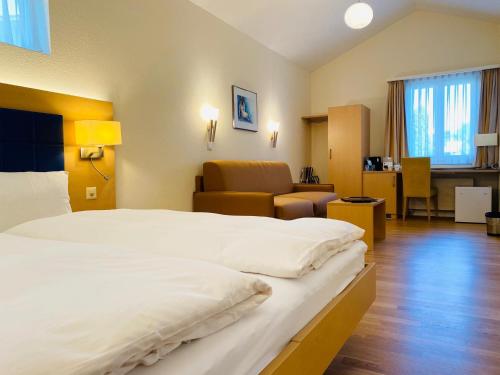 a hotel room with a large bed and a living room at Hotel Felmis in Luzern