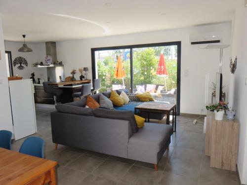 un salon avec un canapé et une table dans l'établissement L'hibiscus, à Narbonne