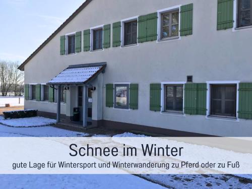 a white building with green shuttered windows at Gut Weihersmühle in Leutershausen