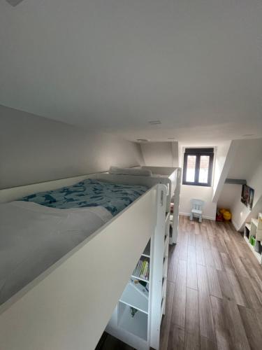 un lit superposé blanc dans une chambre avec parquet dans l'établissement Villa avec piscine 35 min de Paris, à Étiolles