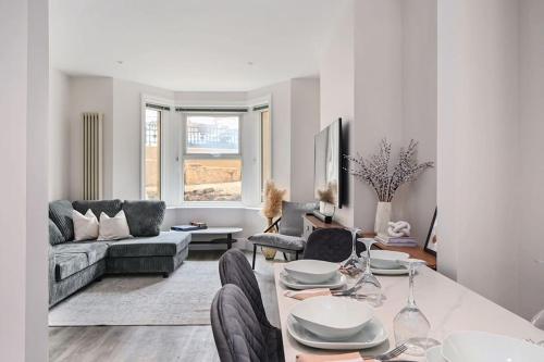 a living room with a table and a couch at Stunning spacious Duplex with garden 141a in Hastings