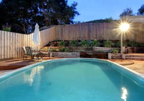 a swimming pool in a backyard with a fence at Seaesta Rye by Ready Set Stay - BYO LINEN & TOWELS in Rye