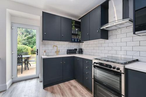 a kitchen with black cabinets and a view of a patio at Stunning spacious Duplex with garden 141a in Hastings