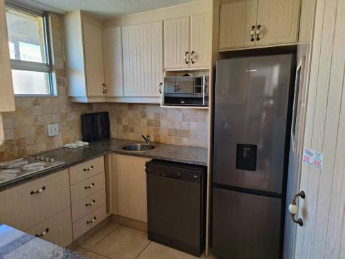 a kitchen with a stainless steel refrigerator and a sink at A Thin Slice of Heaven in Kingsburgh