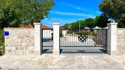 a metal gate with a stone wall at Summer Breeze in Gornji Humac