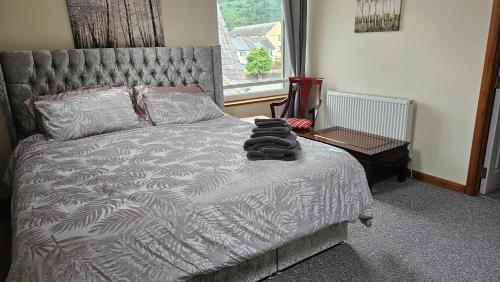a bedroom with a large bed with a silver bedspread at The Apartment at Brook House in Llanberis