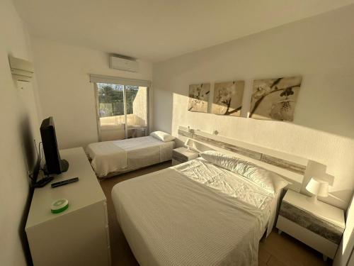 a hotel room with two beds and a television at Benalbeach Paradise in Benalmádena