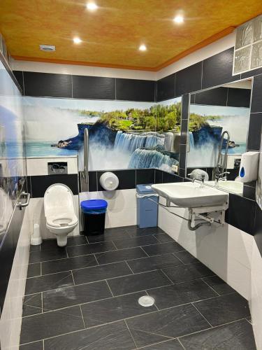 a bathroom with a sink and a toilet and a painting at Benalbeach Paradise in Benalmádena
