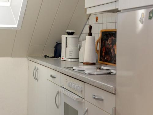 een keuken met witte kasten en een witte koelkast bij Fewo 91 WHG C 25 in Burhave in Burhave