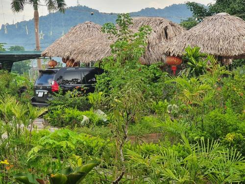 a car parked in front of some huts at Ha Giang Eco Bungalow in Ha Giang