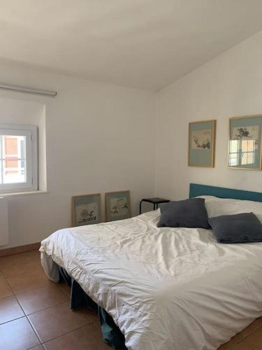 une chambre avec un lit blanc avec trois tableaux au mur dans l'établissement Hypercentre, Cocon pour 6 parking possible, à Marseille