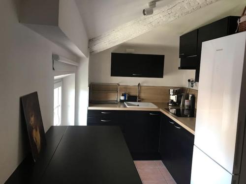 une cuisine avec des armoires noires et un comptoir noir dans l'établissement Hypercentre, Cocon pour 6 parking possible, à Marseille