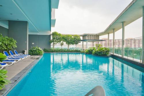 a large swimming pool in a building with blue chairs at Couple Suite at Casa Residency 5 mins walk to LRT, Jalan Alor & Bukit Bintang in Kuala Lumpur