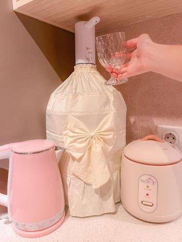 a person holding a wine glass next to a mixer and a bottle at Gold Coast PIK Apartments by Host Jess in Jakarta