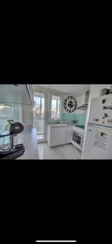 Il comprend une cuisine équipée d'un réfrigérateur et d'une horloge murale. dans l'établissement Appartement 2 chambres, à Marignane