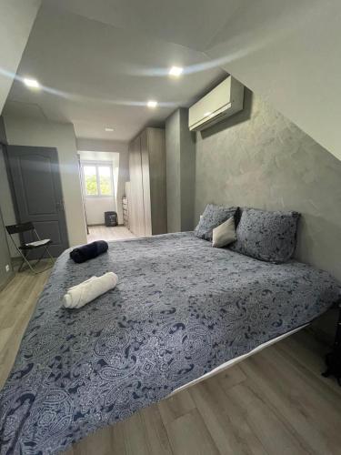 une chambre avec un grand lit avec une couverture violette dans l'établissement Villa avec piscine chauffée à 40min de Paris, à Saintry-sur-Seine