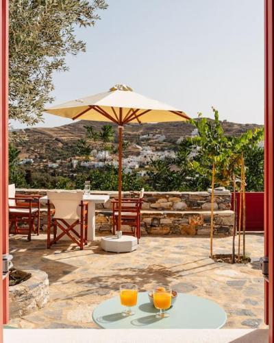 a table with an umbrella and two glasses of orange juice at Avles Studio in Mélanes