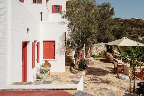 a white house with red doors and a patio at Avles Studio in Mélanes