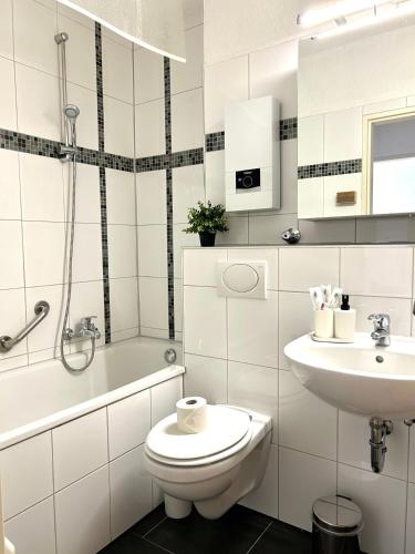 a white bathroom with a toilet and a sink at Wohnung in Monheim am Rhein in Monheim