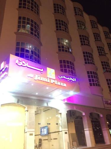 a building with a neon sign in front of it at Al Jimi Plaza Hotel in Al Buraymī