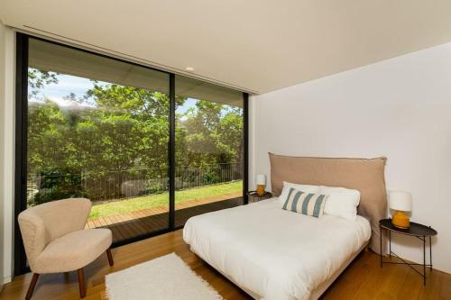 ein Schlafzimmer mit einem Bett und einem großen Fenster in der Unterkunft Casa Da Batoca-Lake view in Ventosa