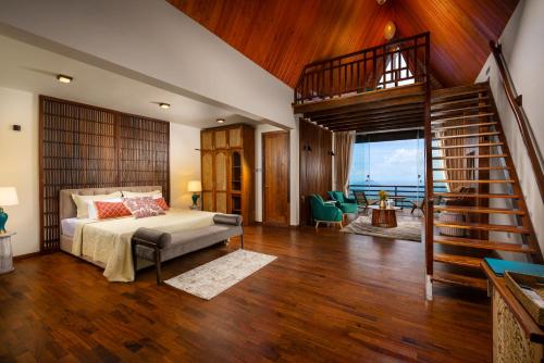 a bedroom with a bed and a spiral staircase at Majentra Ella in Ella
