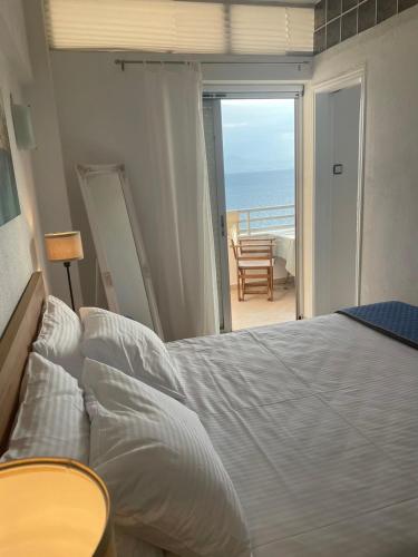 a bedroom with a bed and a view of the ocean at Atlas Zen Blue in Loutraki