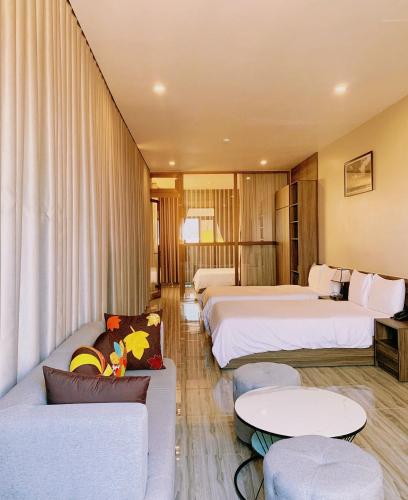 a hotel room with two beds and a couch at Tuyet Suong Hotel in Quang Ngai