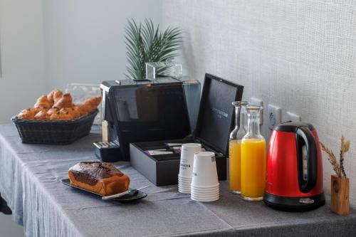 a table topped with a table with bread and a computer monitor at The Originals Boutique, Hôtel Le Pariou, Issoire in Issoire