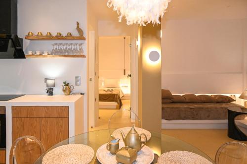 a kitchen and a living room with a glass table at Alento Apartments in Tinos Town