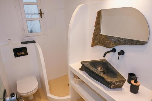 a bathroom with a sink and a mirror at Alento Apartments in Tinos Town