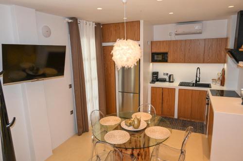 a kitchen with a glass table and some chairs at Alento Apartments in Tinos Town