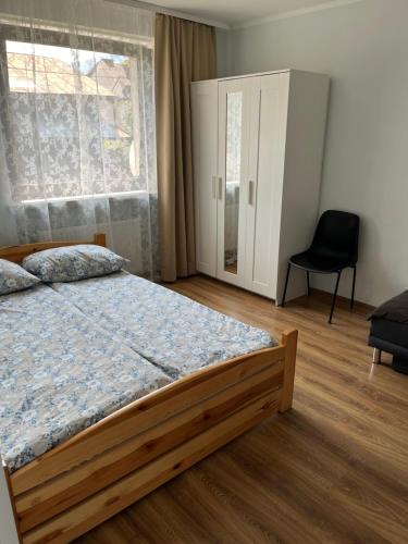 a bedroom with a bed and a window and a chair at Dwunastka in Zakopane