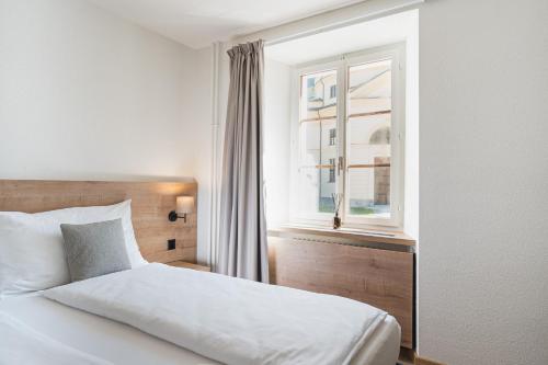 a bedroom with a white bed and a window at Hotel Brocco & Posta in San Bernardino