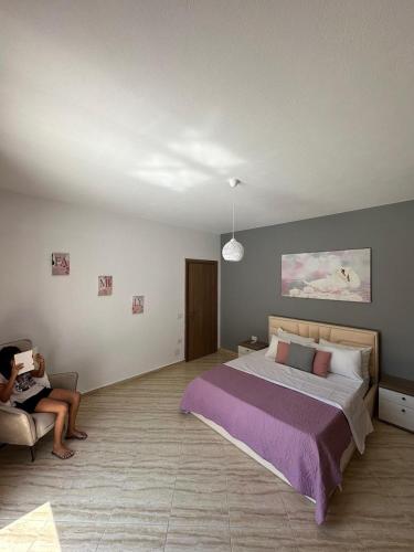 a woman sitting in a chair in a bedroom at SWEET HOME 1 in Himare