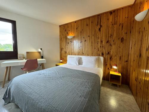 - une chambre avec un lit et un mur en bois dans l'établissement La Toise - 8 personnes - Wifi - Rêve au Mans, au Mans