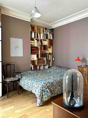 une chambre avec un lit et une étagère dans l'établissement Appartement de charme près Montmartre, à Paris