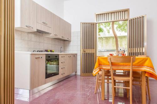 a kitchen with a table with a yellow cloth on it at Villa Kareema 2D con accesso diretto alla Spiaggia di San Pietro in Bevagna in San Pietro in Bevagna