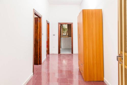 a hallway with two doors and a room with pink tiles at Villa Kareema 2D con accesso diretto alla Spiaggia di San Pietro in Bevagna in San Pietro in Bevagna