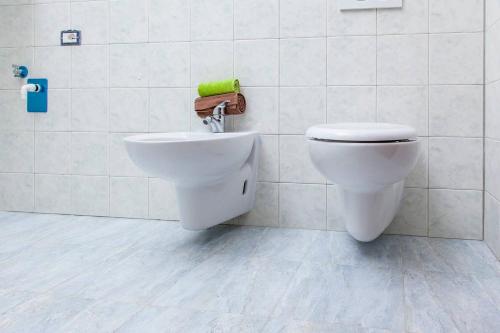a bathroom with a toilet and a green towel at Villa Kareema 2D con accesso diretto alla Spiaggia di San Pietro in Bevagna in San Pietro in Bevagna
