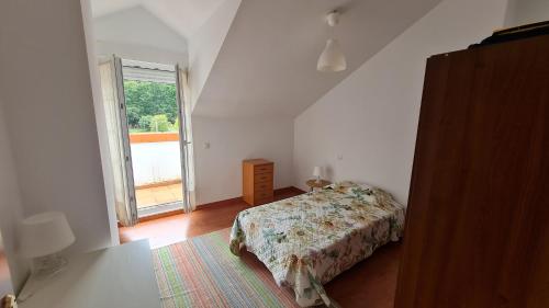 VillabáñezにあるEl ático de Marinucaのベッドと大きな窓のある寝室