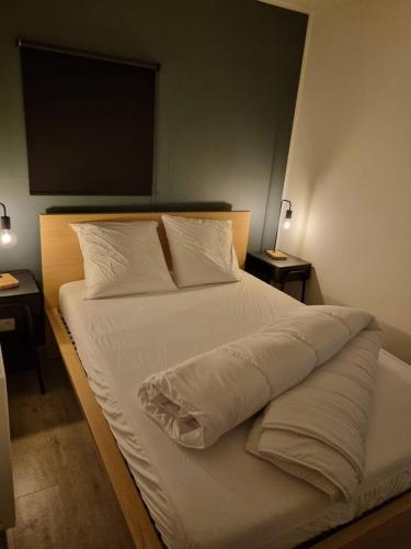 a bedroom with a bed with white sheets and pillows at Le P'tit Padré in Jalhay