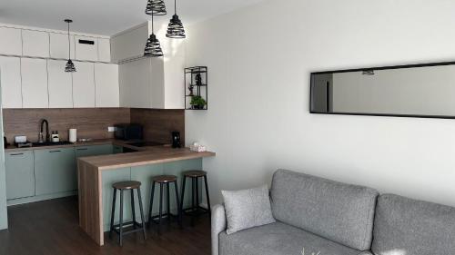 a living room with a couch and a kitchen at Apartament Rytm - Metro Kabaty in Warsaw
