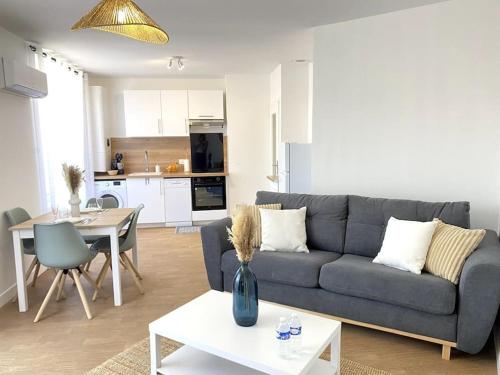 un salon avec un canapé et une table dans l'établissement Le Brennou- Proche centre- Neuf-climatisé-tout équipé, à Châteauroux