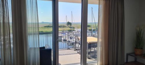 a room with a balcony with a view of a marina at Luxe 4 persoons appartement in Residence Marina Kamperland 2c in Kamperland